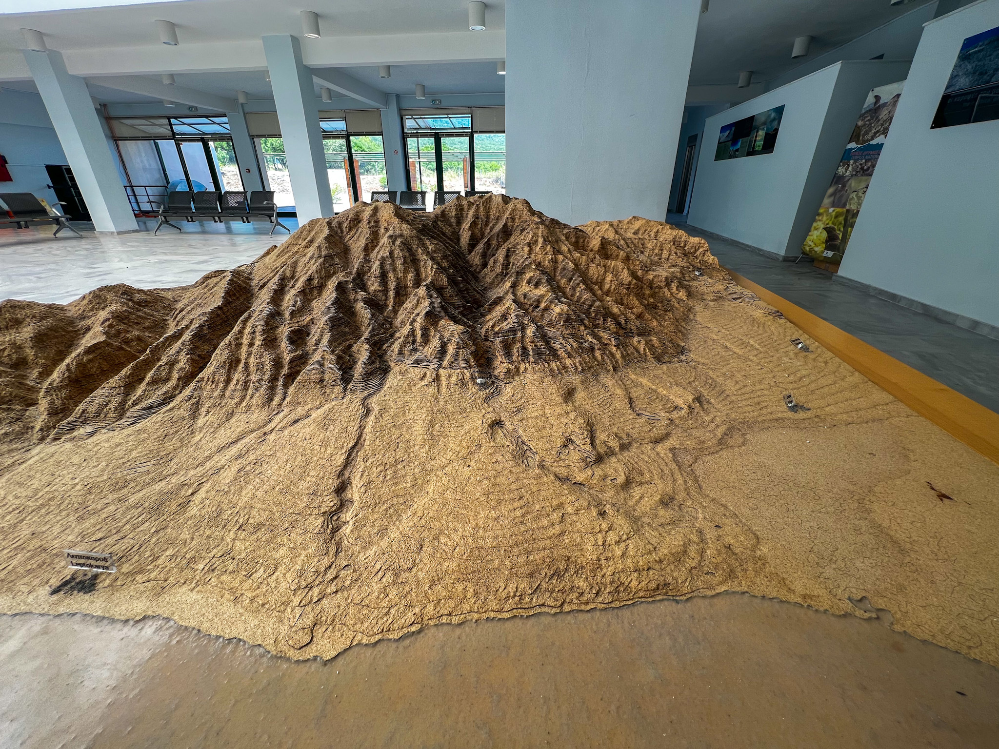 A detailed sand topographic model inside the Olympus National Park Information Center, showing the intricate landscape features of the park.