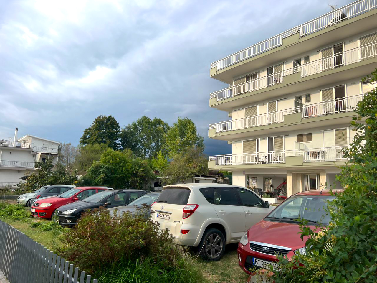 Exterior view of Hotel Prado with secure parking area and nearby greenery