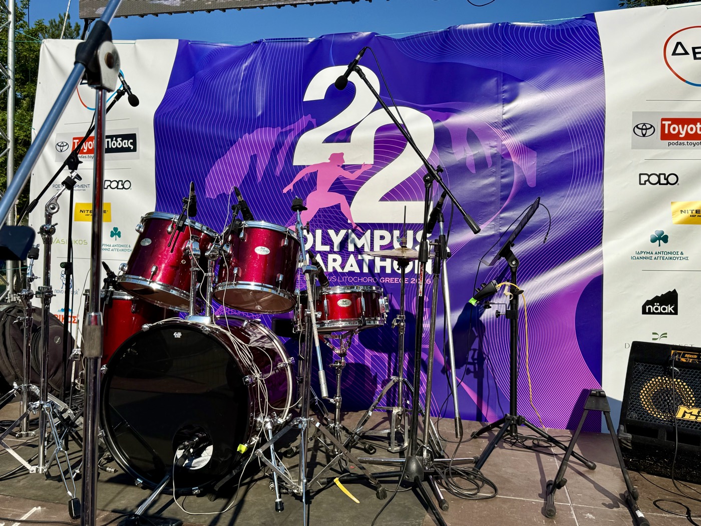 Ediția 22 Olympus Marathon în Litochoro scenă centrală cu banner sponsori